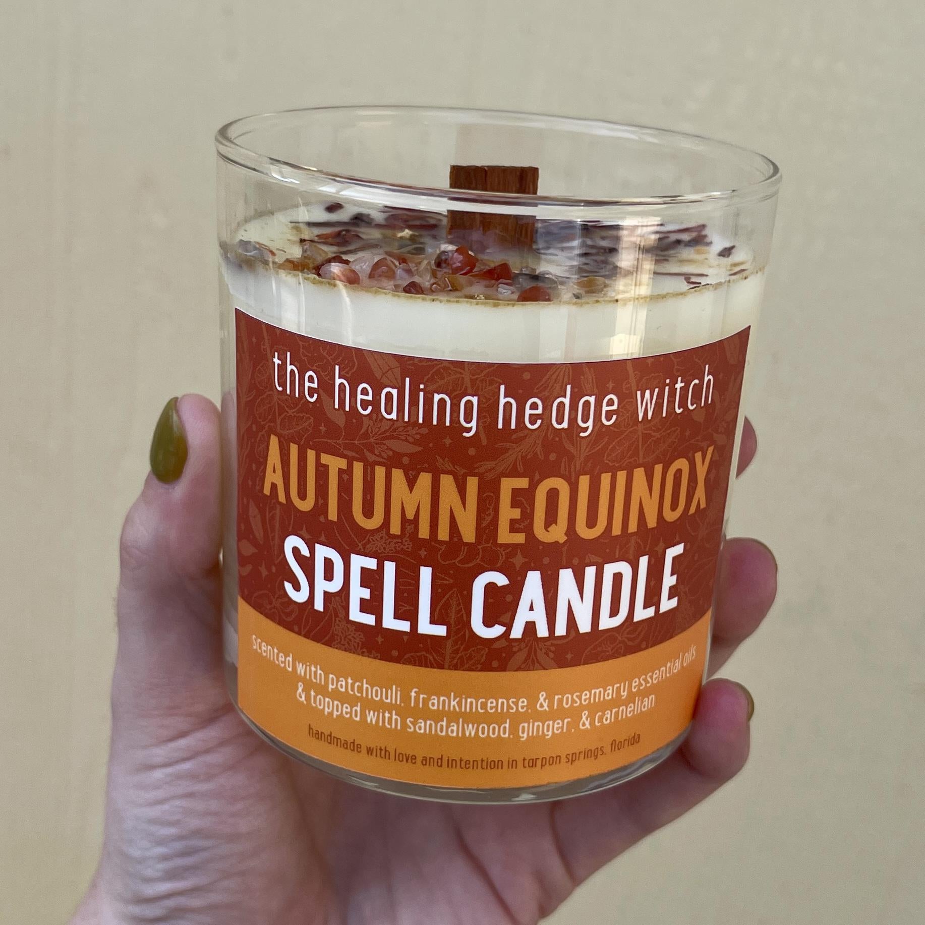 8 ounce autumn equinox spell candle scented with patchouli, frankicense, and rosemary essential oils and topped with sandwood, ginger, and carnelian.