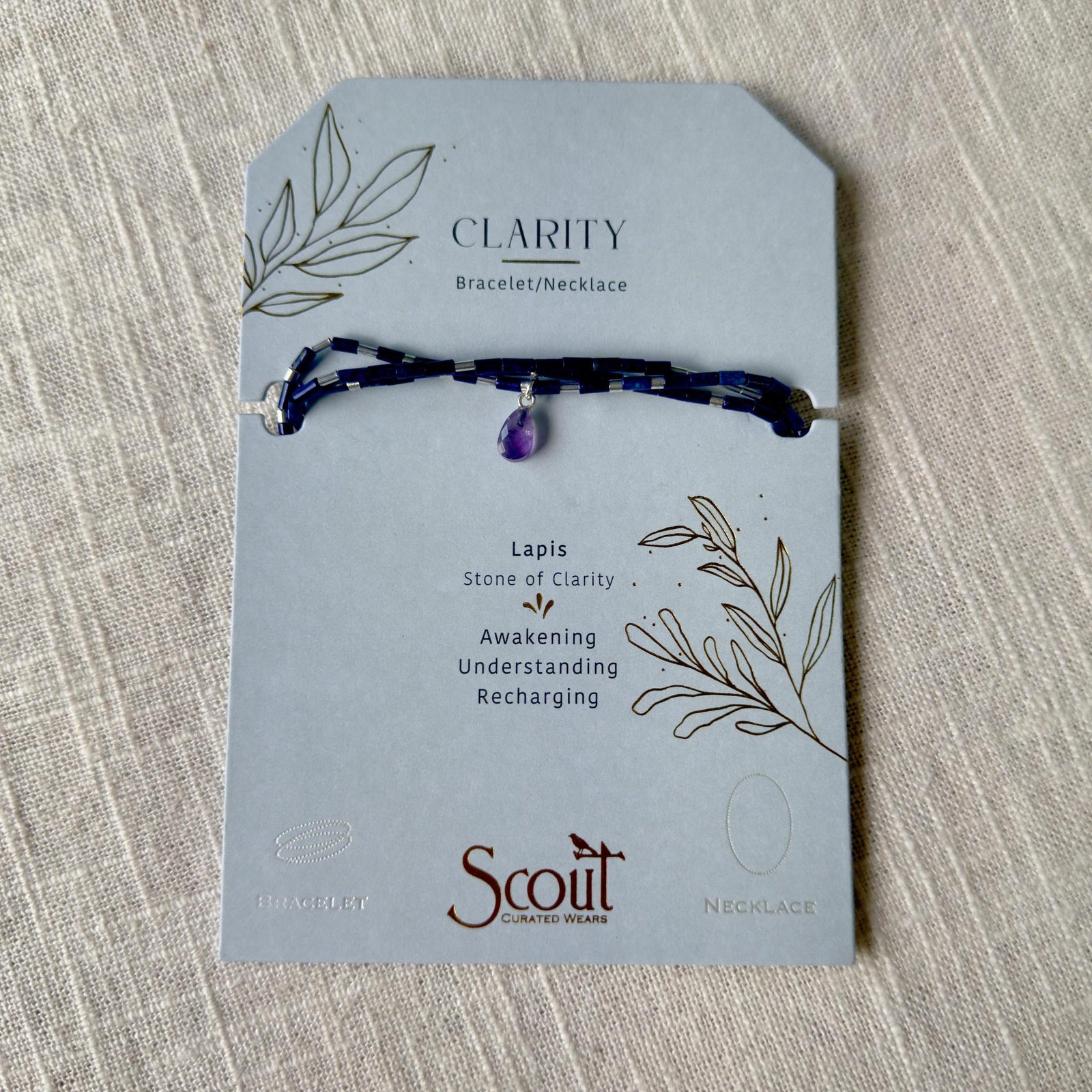 The Healing Hedge Witch's Teardrop Stone Wrap, a blue lapis semi precious gemstone bracelet with a teardrop charm, comes on a Clarity card describing lapis as the stone of clarity for awakening, understanding, and recharging.