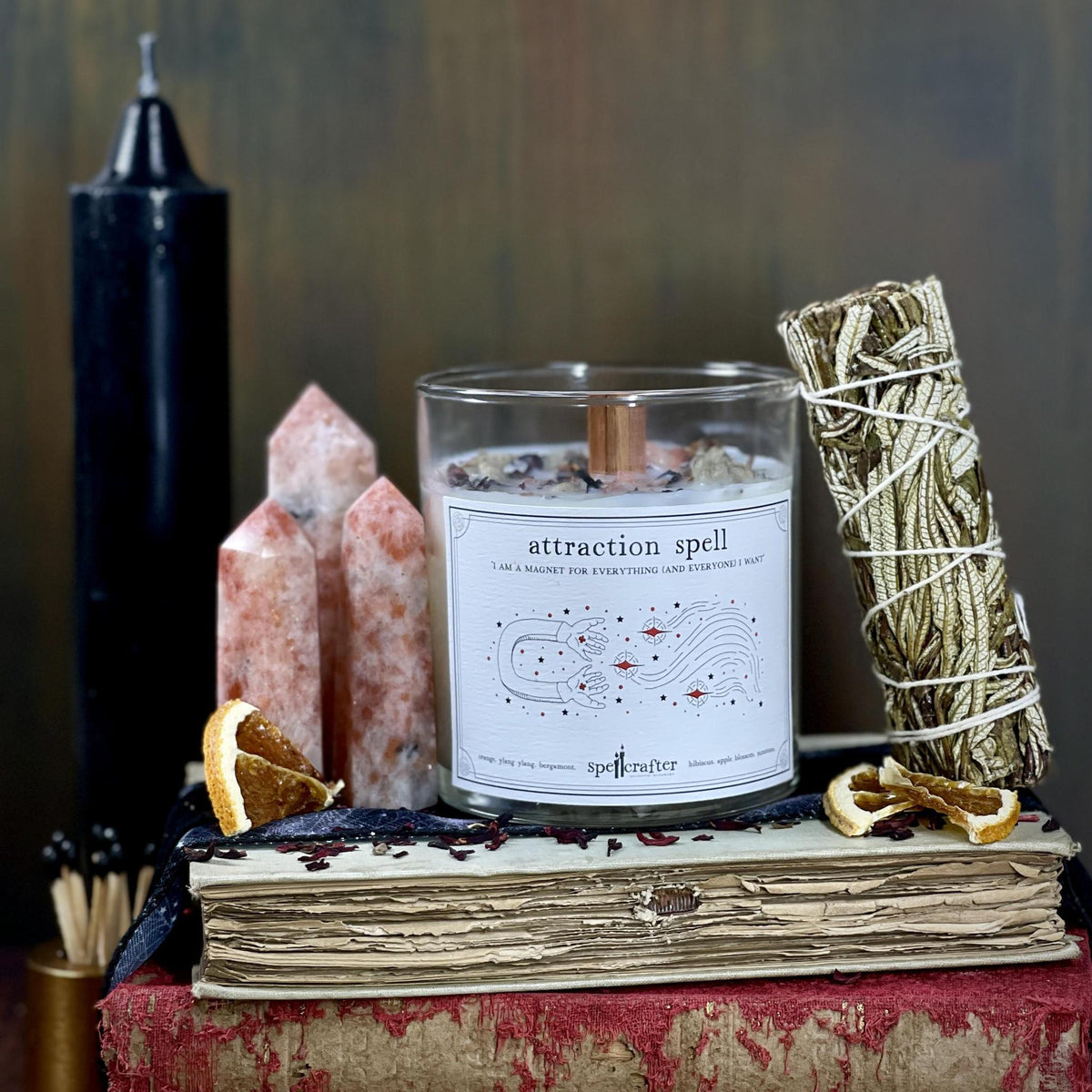 Attract your manifestations with this hand poured, small-batch 8-ounce spell candle. Scented with orange, ylang ylang, and bergamot essential oils &amp; topped with hibiscus, apple blossom and sunstone.