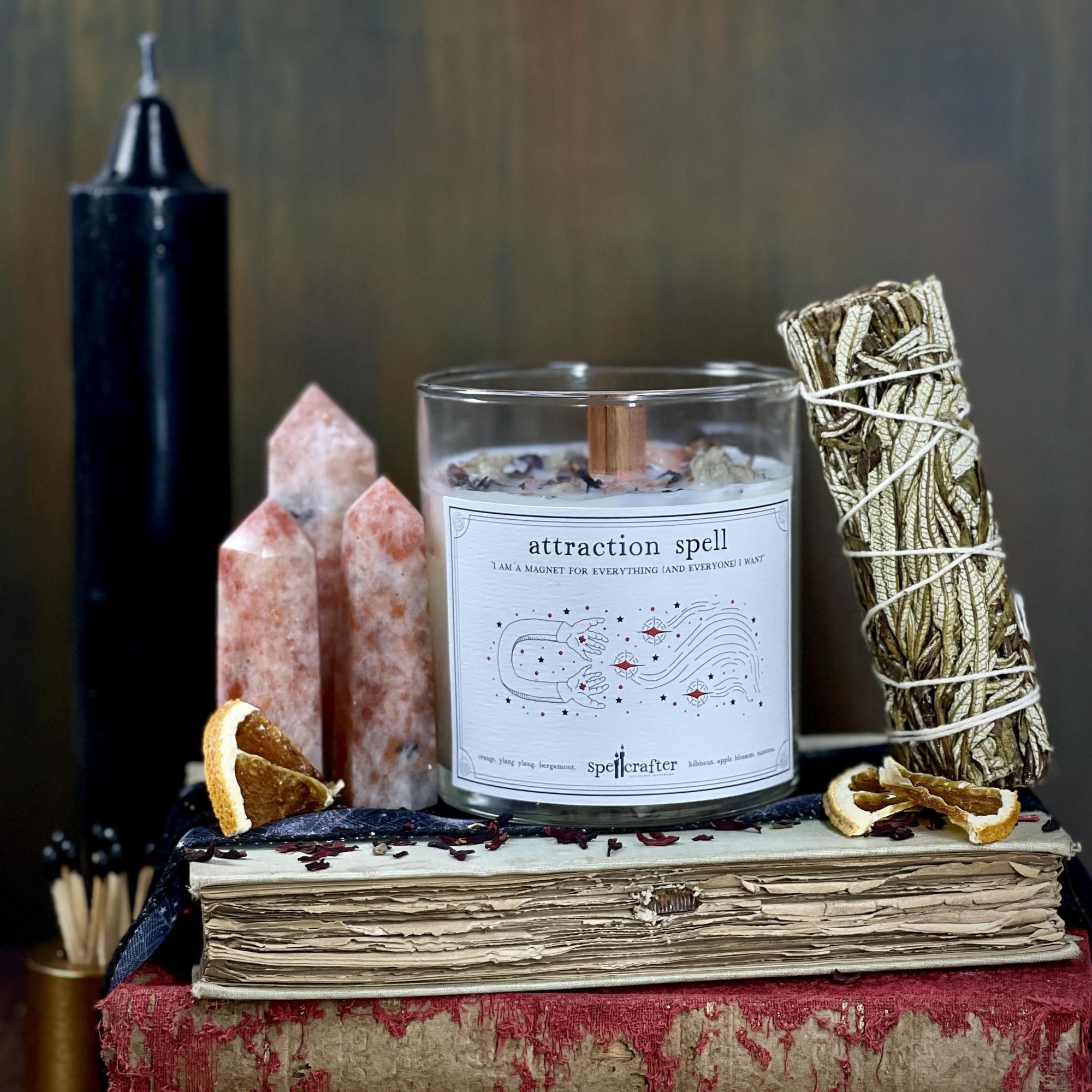 Attract your manifestations with this hand poured, small-batch 8-ounce spell candle. Scented with orange, ylang ylang, and bergamot essential oils & topped with hibiscus, apple blossom and sunstone.