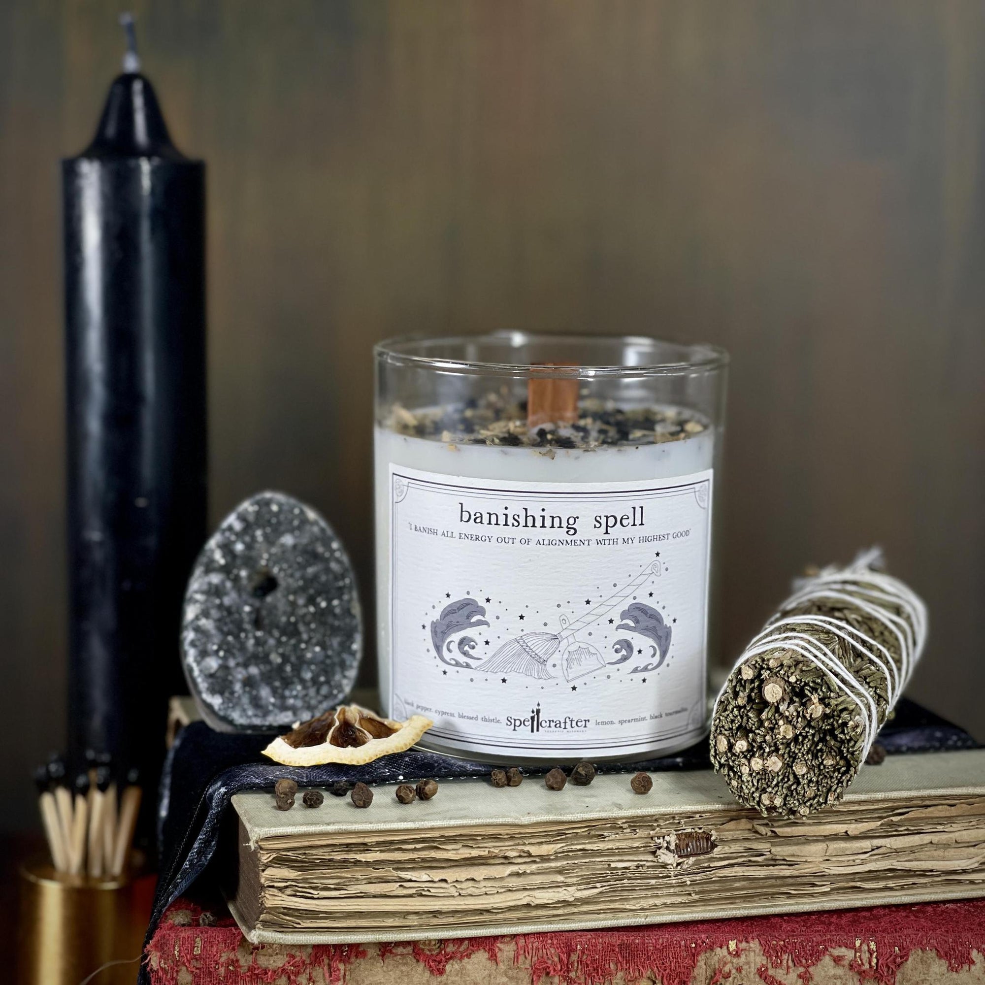 Banish unwanted energy in your life with this hand poured, small-batch 8-ounce spell candle. Scented with black pepper, cypress, and lemon essential oils & topped with blessed thistle, spearmint, and black tourmaline.