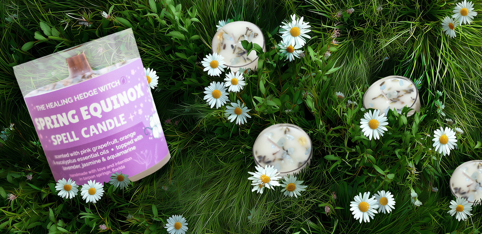 A labeled Spring Equinox Spell Candle sits among daisies and green grass; several round candles with botanical elements are also scattered on the grass.