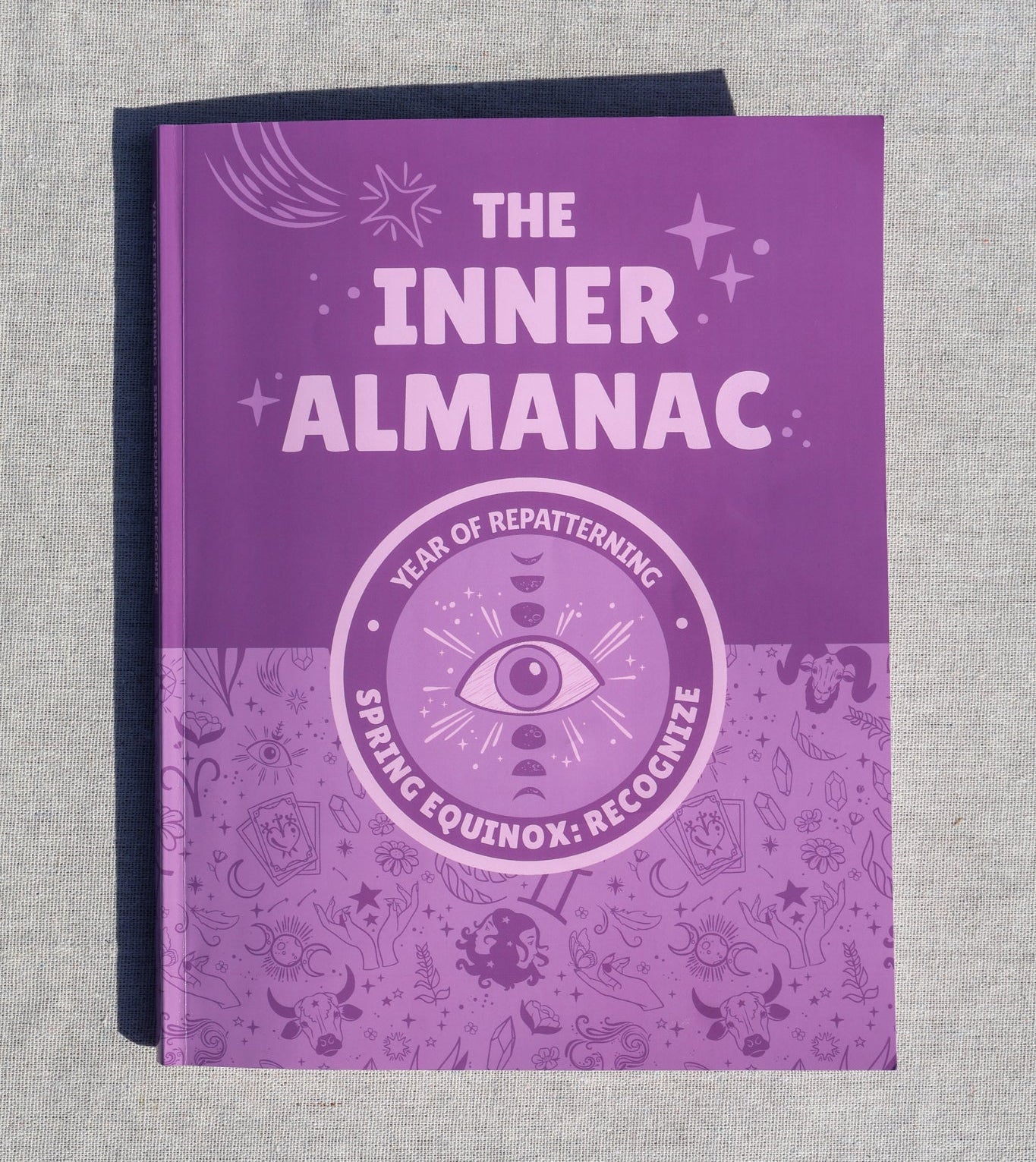 Purple book titled 'The Inner Almanac' on a textured gray background