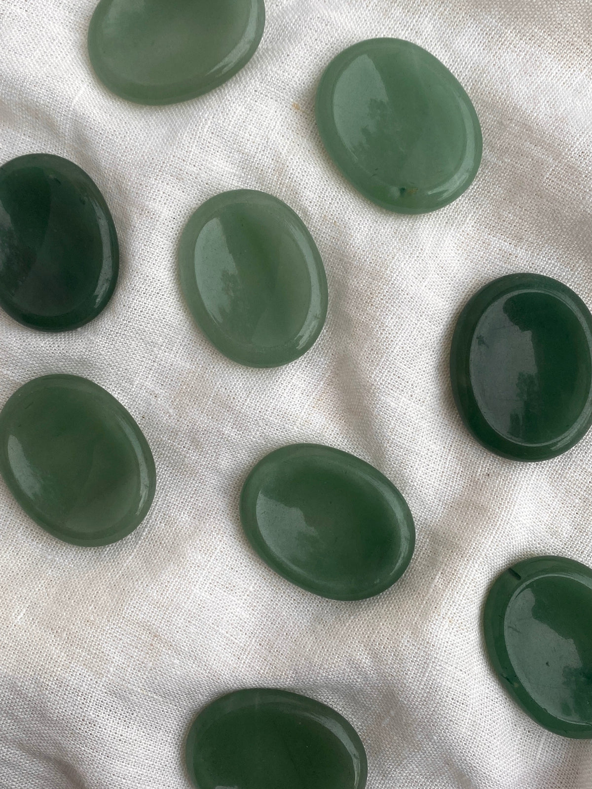 Green Aventurine Palm Stones by The Healing Hedge Witch, featuring smooth, oval shapes in varied green shades with subtle light reflections—ideal for abundance and supporting the Heart chakra.