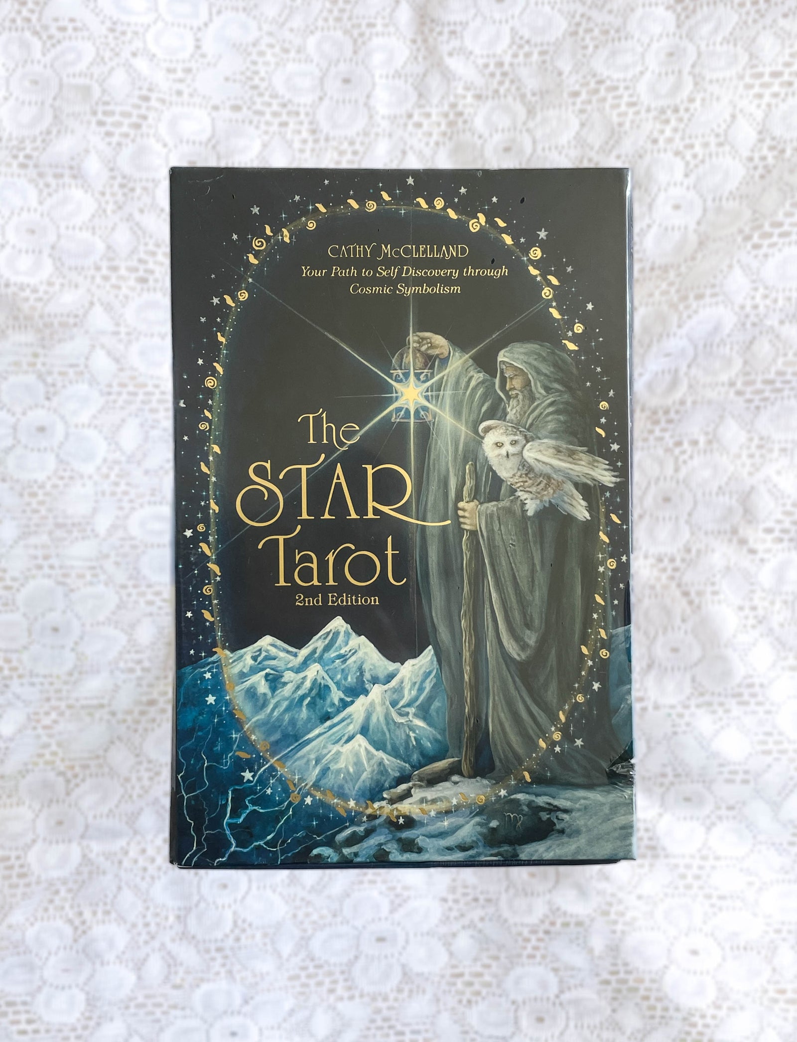 The Star Tarot by The Healing Hedge Witch: 2nd Edition deck featuring mystical artwork of a robed figure with a staff and white owl, set against mountains, stars, and glowing golden designs on a dark background.