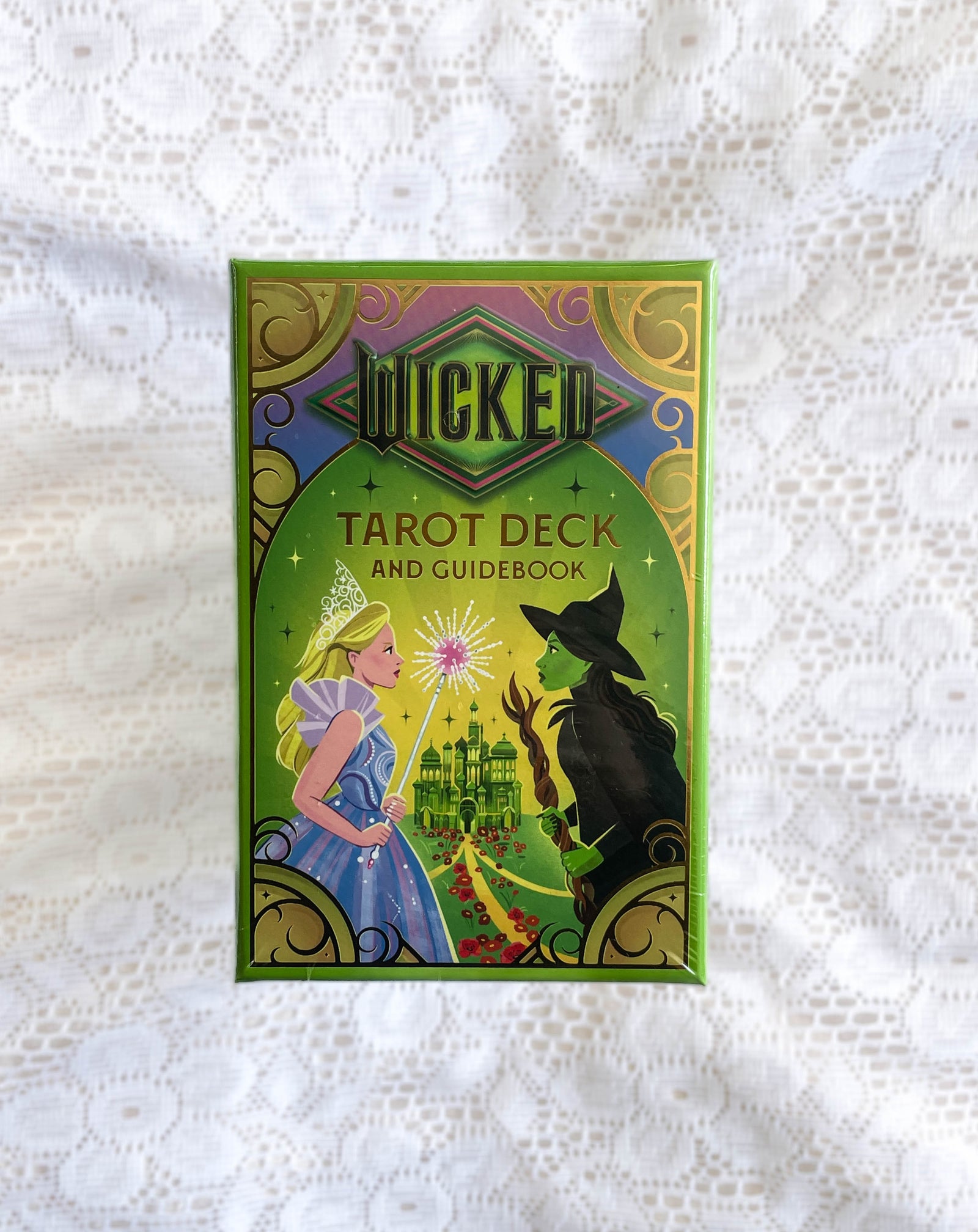 A green box labeled Wicked Tarot Deck by The Healing Hedge Witch features artwork of a blonde woman in blue and a green-skinned witch facing each other with a magical castle and sparkles between them.