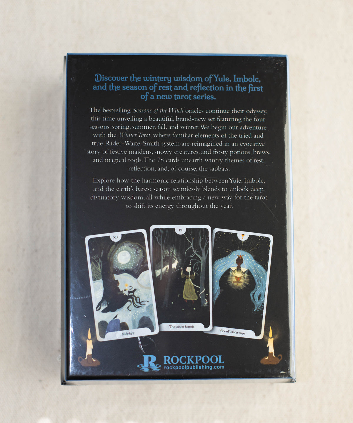 A box with text describing the Seasons of the Witch Winter Tarot by The Healing Hedge Witch. The back features three illustrated cards—Midsummer, Yule, and The Hermit—and the Rockpool Publishing logo at the bottom.