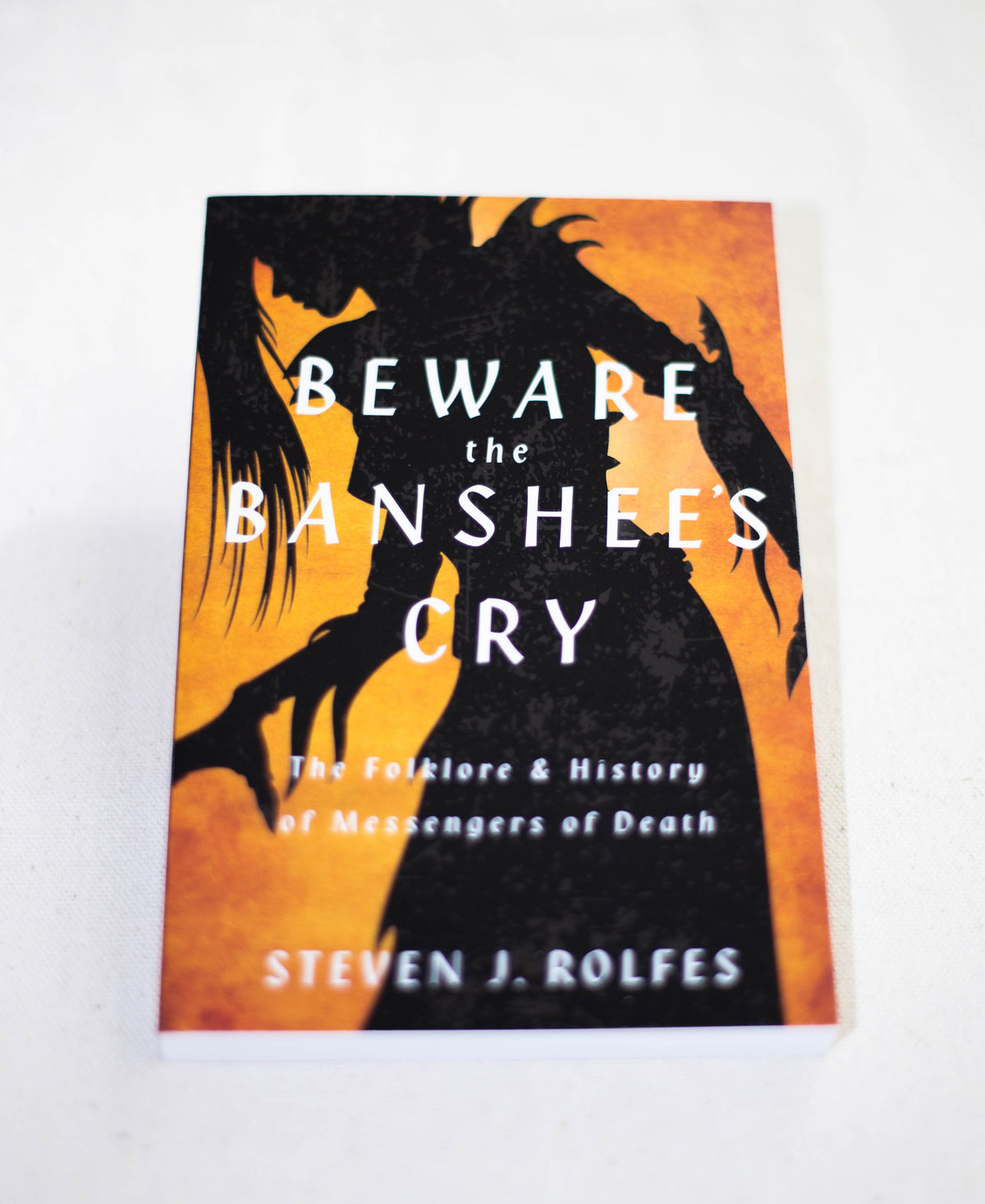Beware the Banshees Cry by The Healing Hedge Witch features an orange and black cover with a shadowy, ghostly figure.