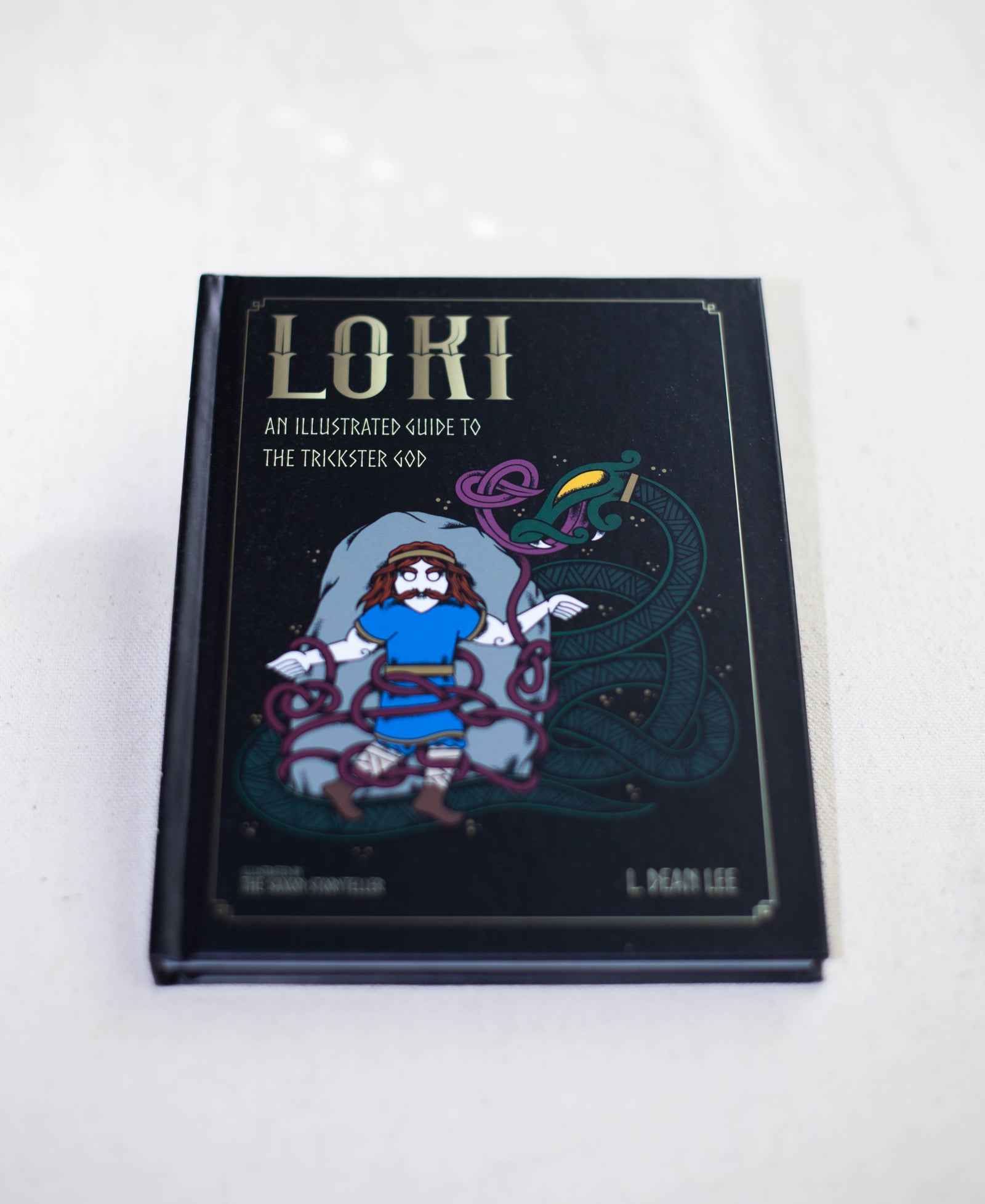 Loki by The Healing Hedge Witch features a cartoon illustration of Loki entangled in serpents on a black cover with gold decorative elements.