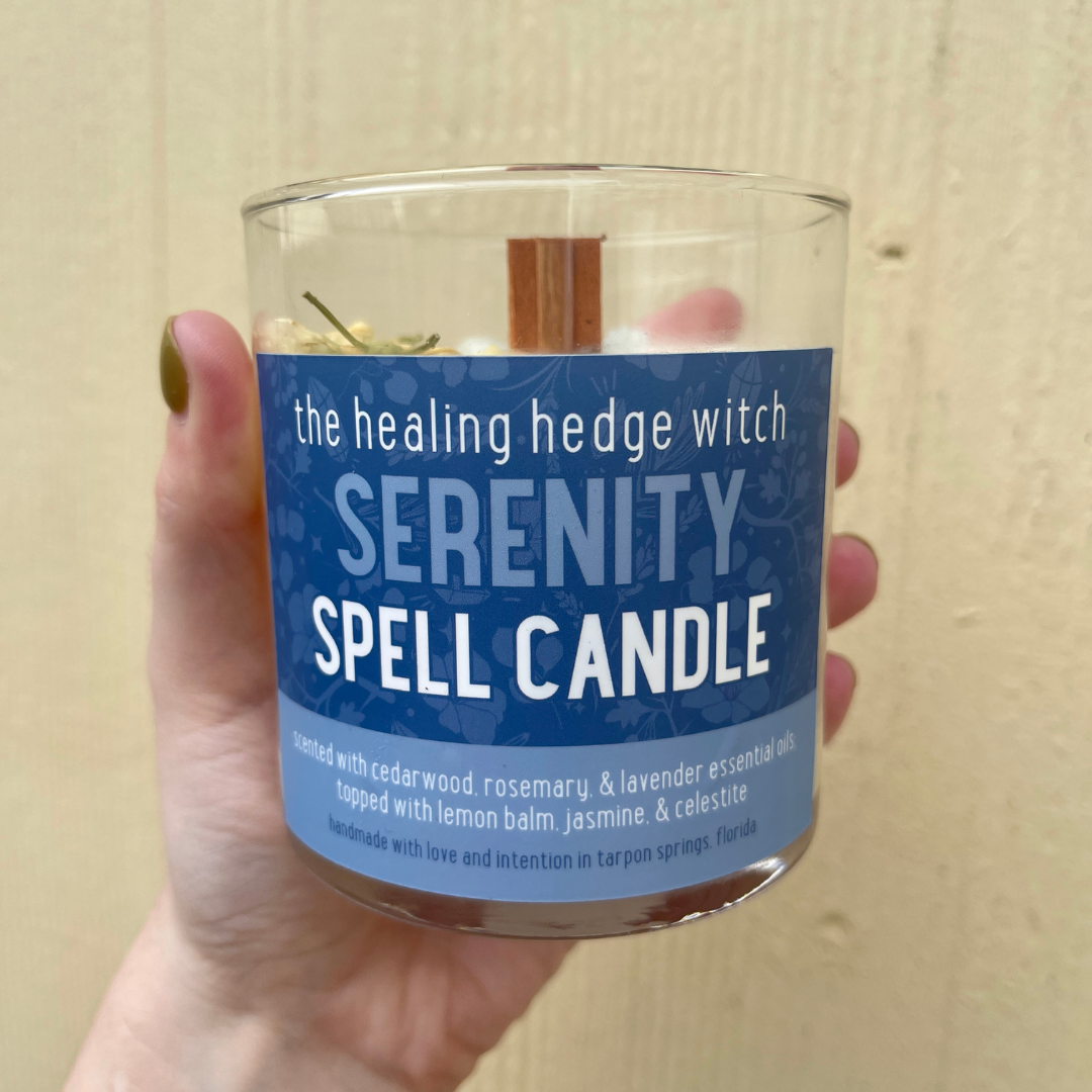Serenity spell candle hand-poured, small-batch 8-ounce spell candle. Scented with cedarwood, rosemary, &amp; lavender essential oil; topped with lemon balm, jasmine, &amp; celestite
