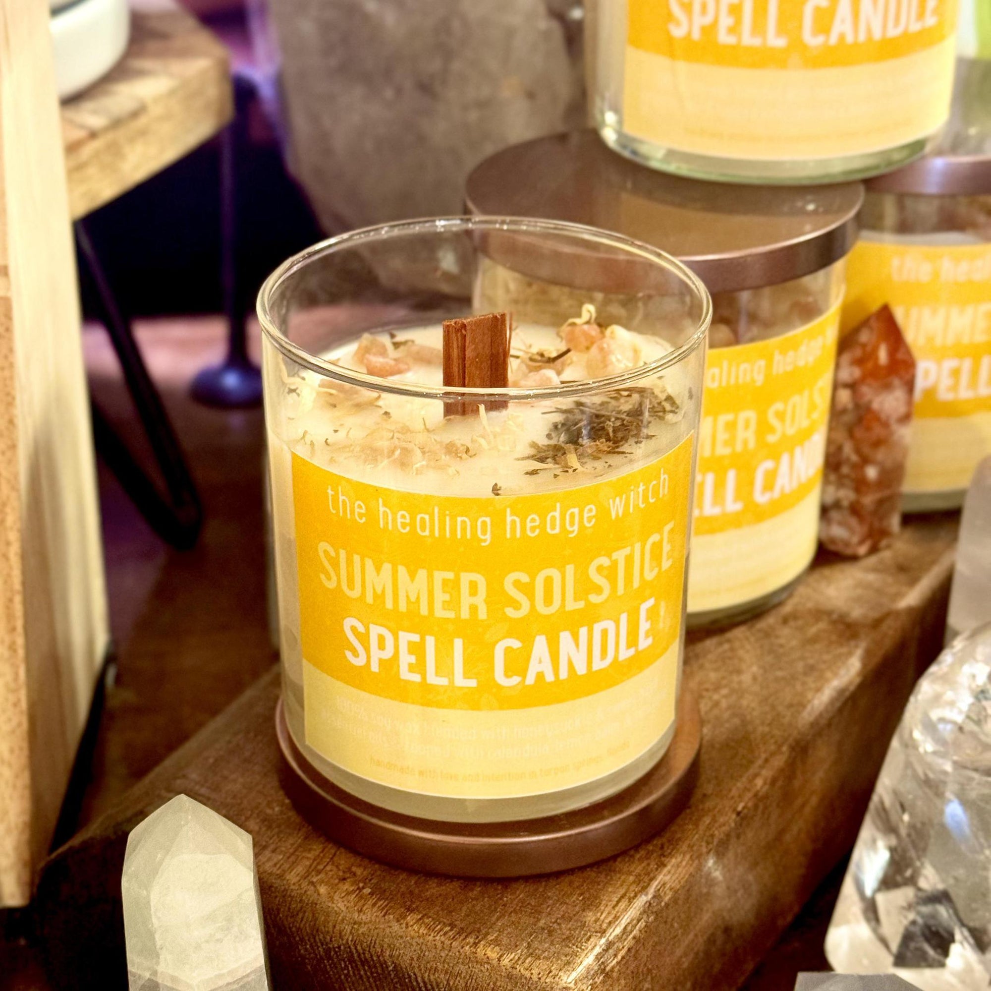 Summer Solstice Spell Candle hand-poured, small-batch 8 oz spell candle. Scented with honeysuckle & sweet basil essential oil and topped with calendula petals, lemon balm, and sunstone.