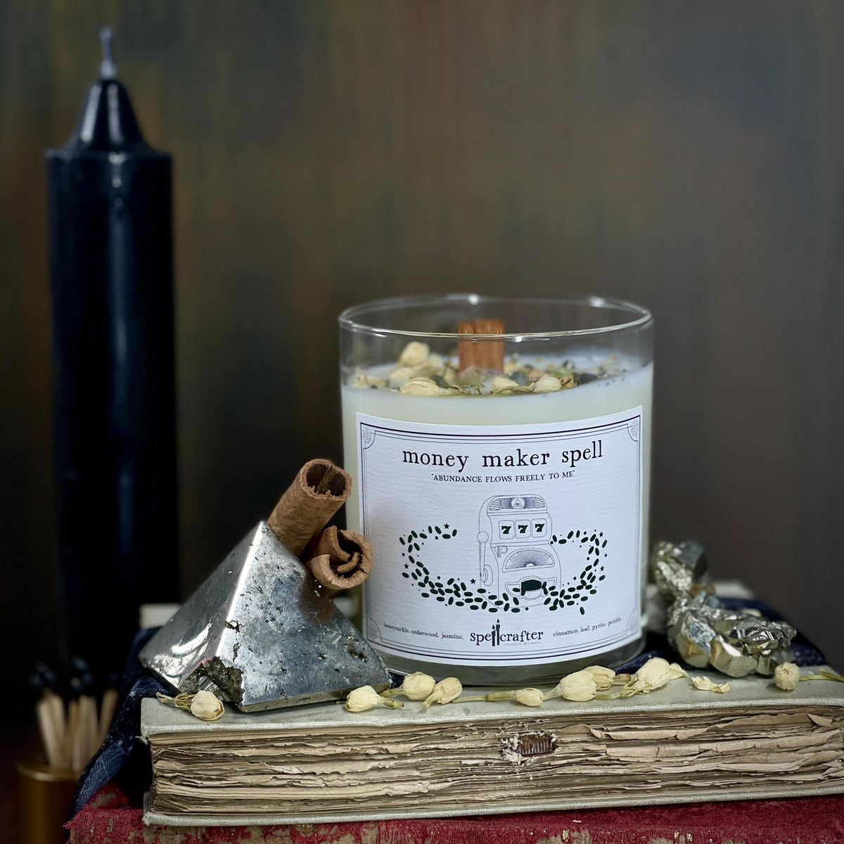 money maker spell candle Invite prosperity in with this hand poured, small-batch 8-ounce spell candle. Scented with honeysuckle, cedarwood, and cinnamon leaf essential oils &amp; topped with jasmine, pyrite, and peridot