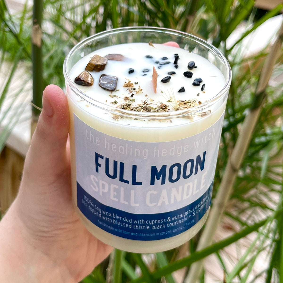 Full Moon Spell Candle A hand-poured, small-batch 8-ounce spell candle made to aid in your workings during the full moon. Scented with cypress and eucalyptus essential oils &amp; topped with blessed thistle, tigers eye, and black tourmaline.