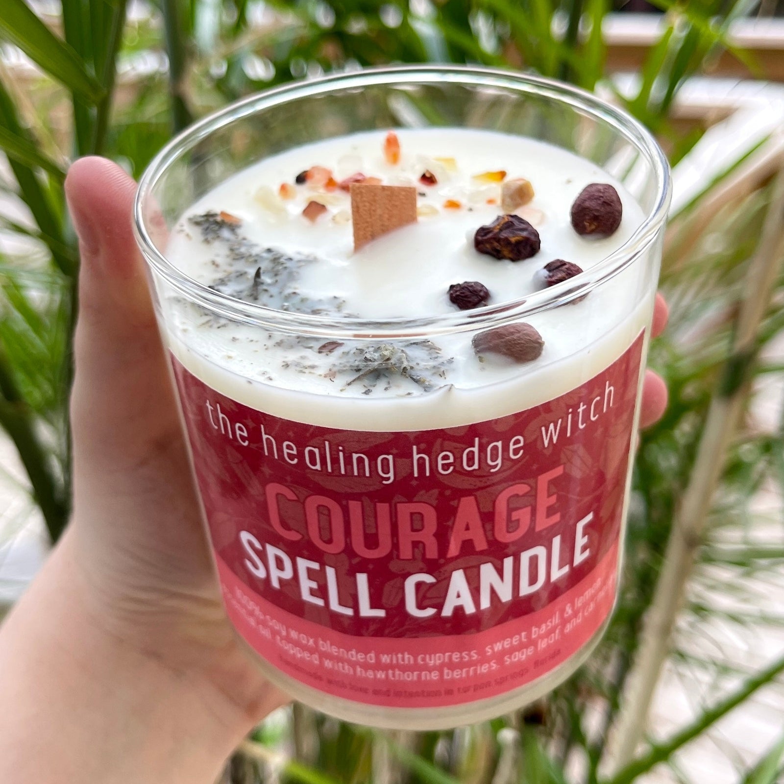 Courage Spell Candle Bring courage forward in your life with this hand-poured, small-batch 8-ounce spell candle. Scented with sweet basil, cypress, and lemon essential oils & topped with hawthorn berries, sage, and carnelian.