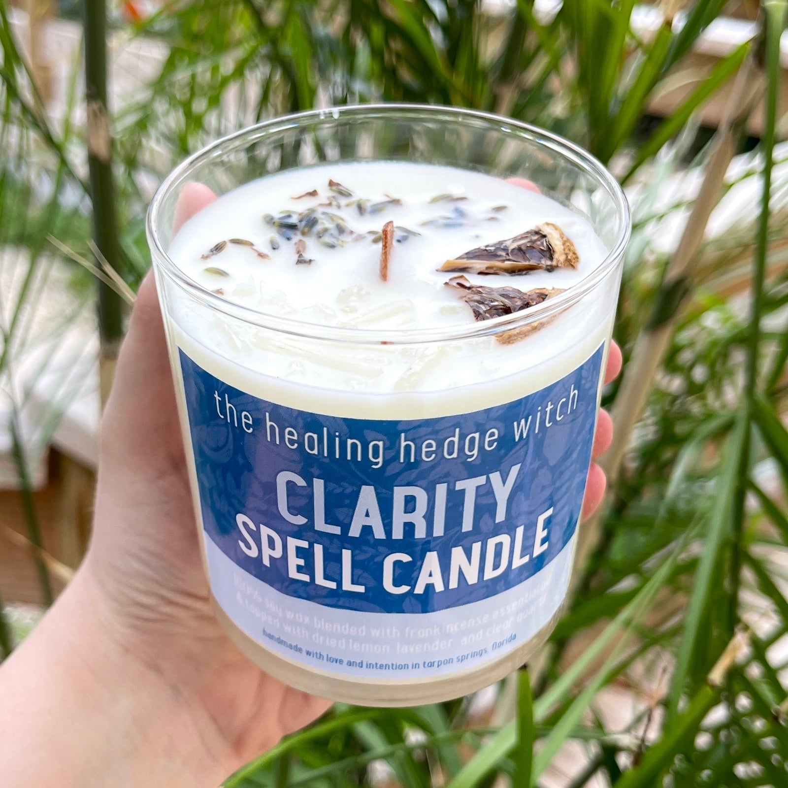 Clarity Spell Candle Bring clarity forward in your life with this hand-poured, small-batch 8-ounce spell candle.. Scented with frankincense essential oil & topped with dried lemon, lavender, and clear quartz.