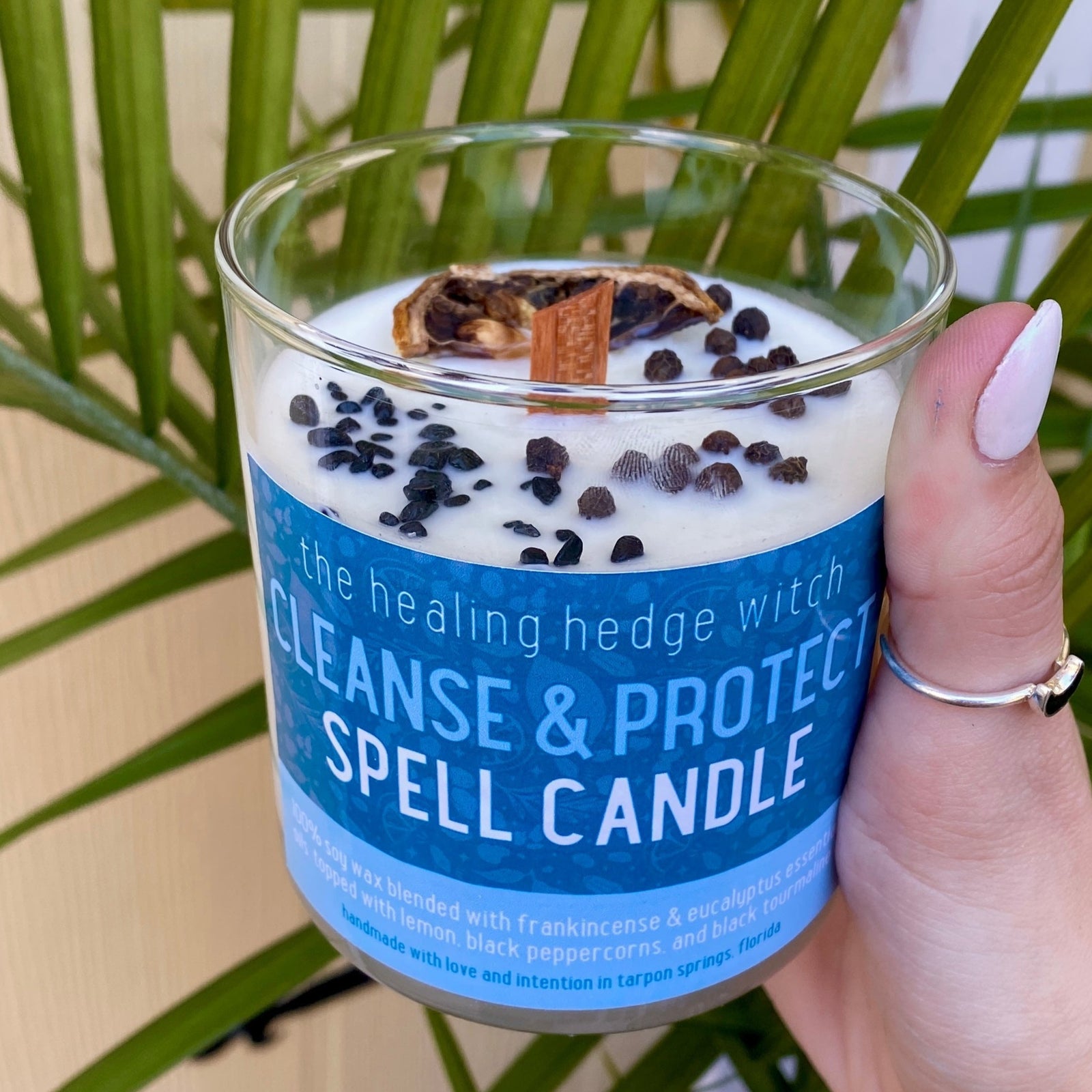 Cleanse and protect your space and energy with this hand-poured, small-batch, 8-ounce spell candle. Scented with frankincense and eucalyptus essential oils & topped with black peppercorns, lemon, and black tourmaline.