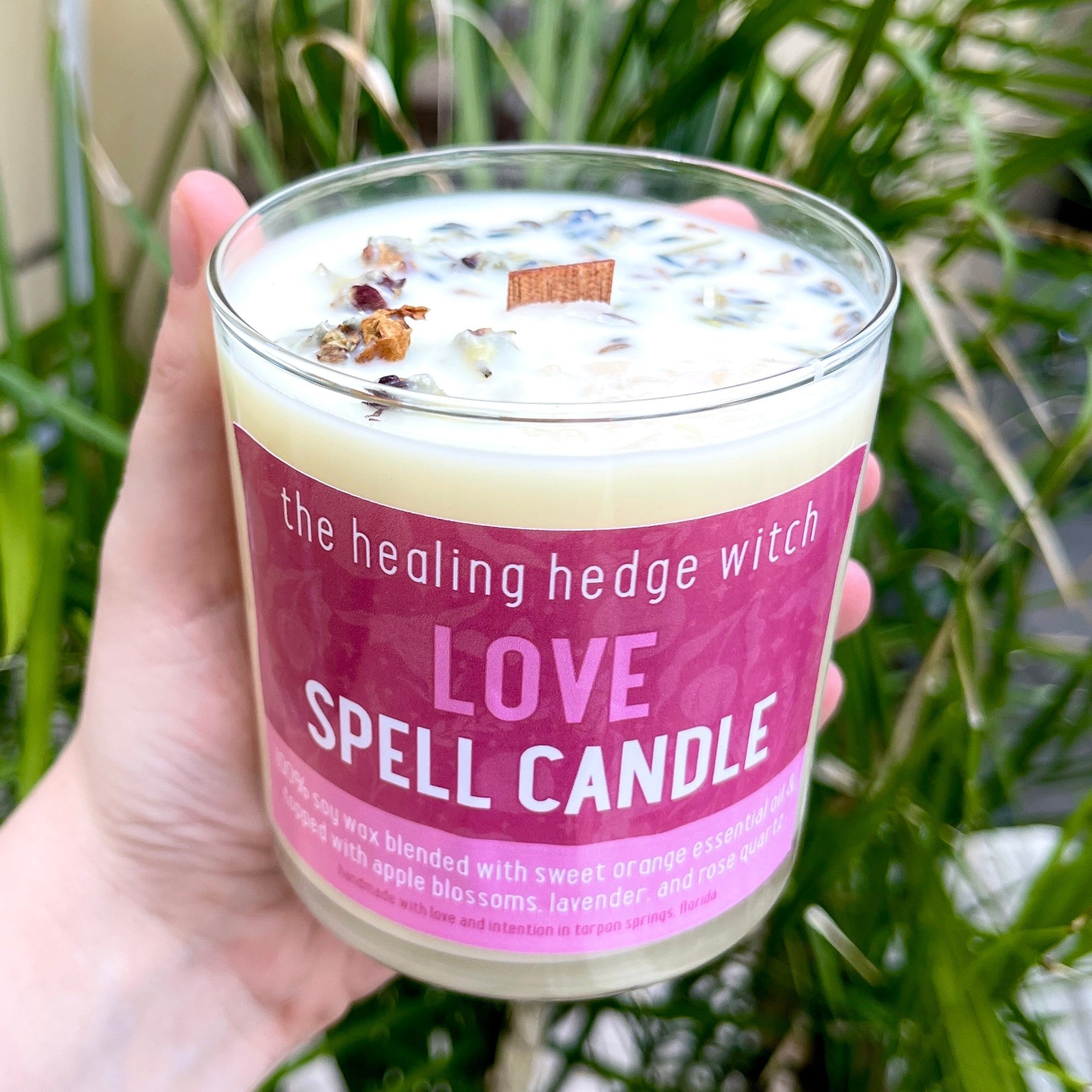 Love Spell Candle Bring love forward in your life with this hand-poured, small-batch 8-ounce spell candle. Scented with orange essential oil and topped with apple blossoms, lavender, and rose quartz.